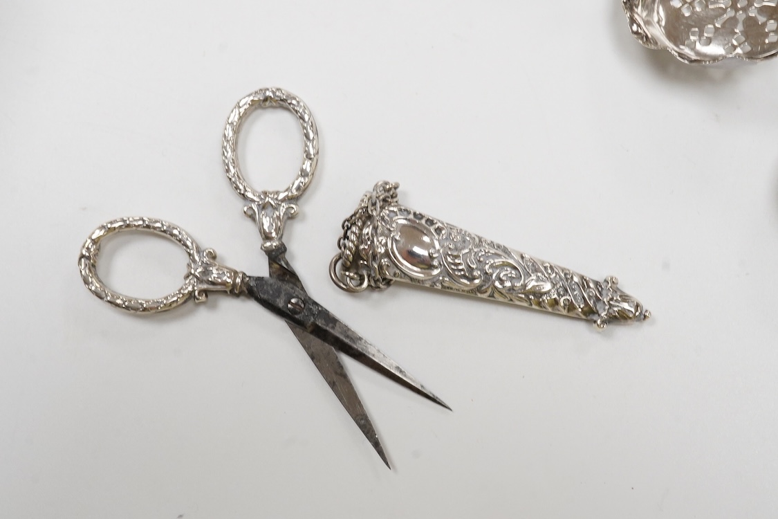 Small silver and white metal, including an Edwardian silver tea strainer, import marks for London, 1908, 15.7cm, a late Victorian silver sifter spoon, silver handled scissors with case, a white metal corkscrew and a whit